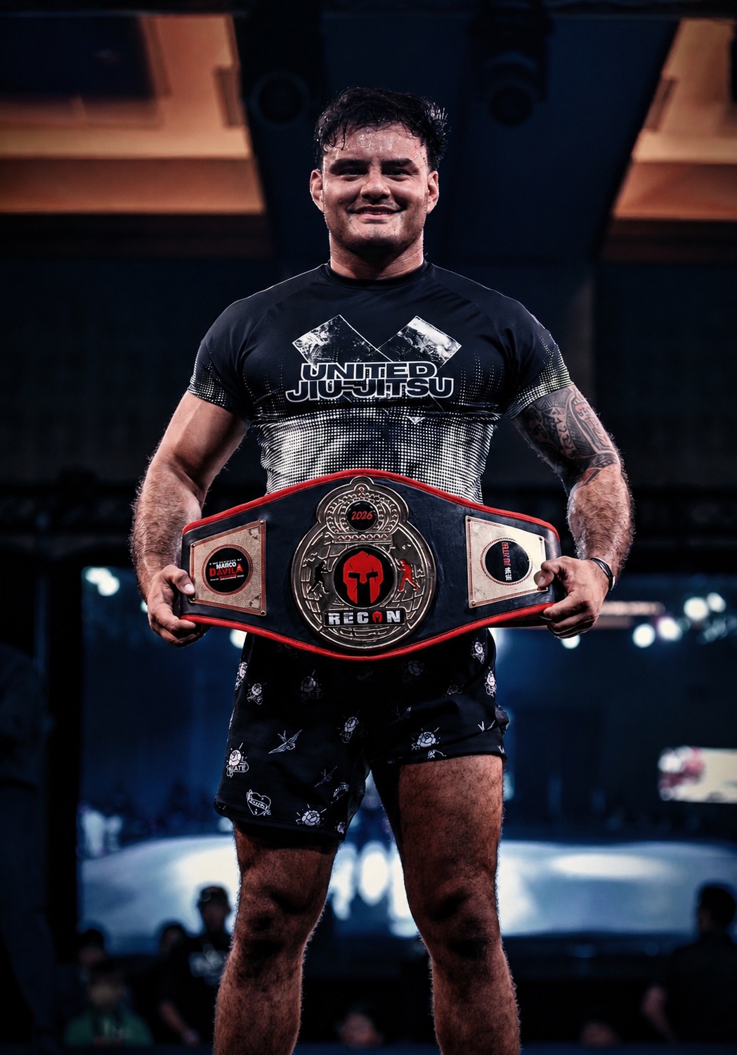 Professor Carlos Henriquez holding his 2026 RECON championship belt
